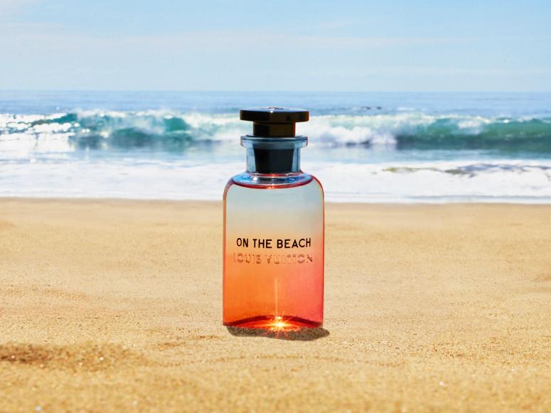 A glass bottle of perfume on a beach