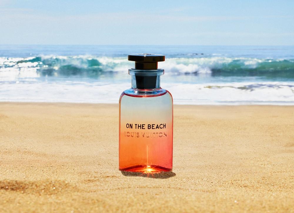 A glass bottle of perfume on a beach