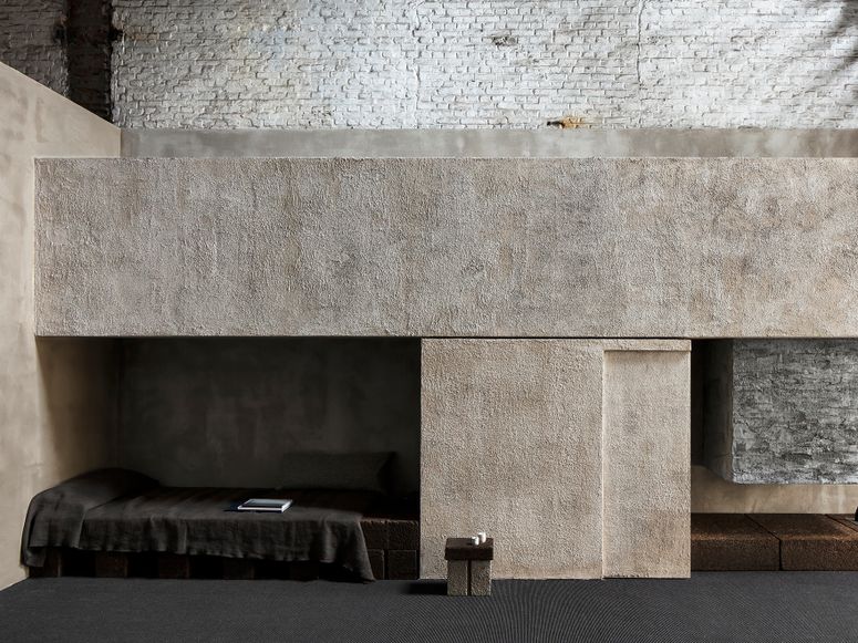 A bedroom with cork and brick walls