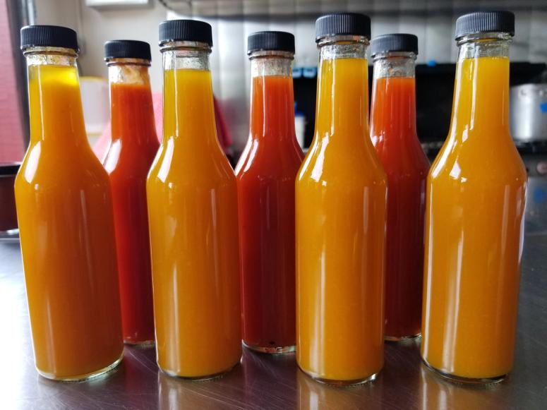 Orange and red hot sauces, unlabeled.