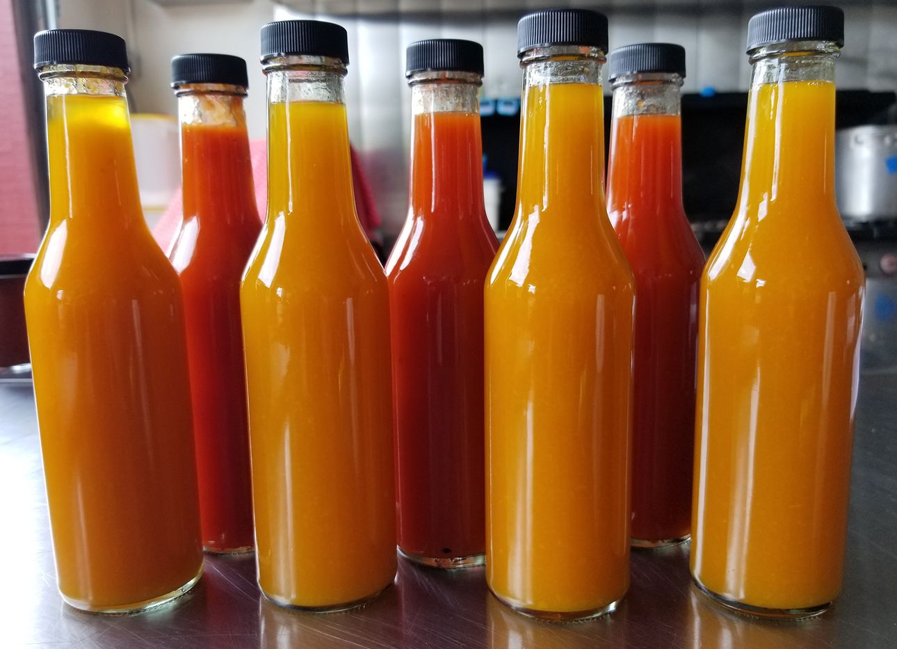 Orange and red hot sauces, unlabeled.