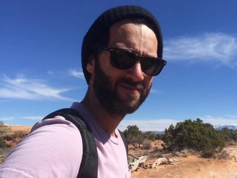 Keith Abramsson in sunglasses, walking through the desert.