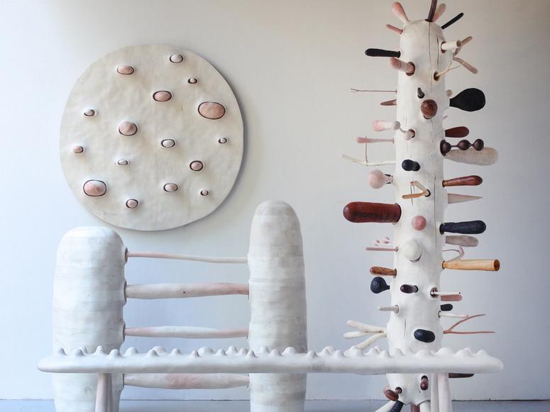 Bulbous white sculptures with various forms extending from them in a gallery.