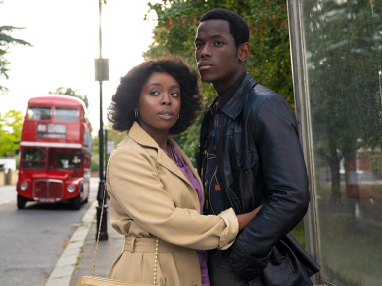 A still from Steve McQueen's "Small Axe" depicting two people holding each other on the street in London