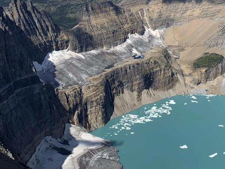 A large glacier on a cliff above the ocean.