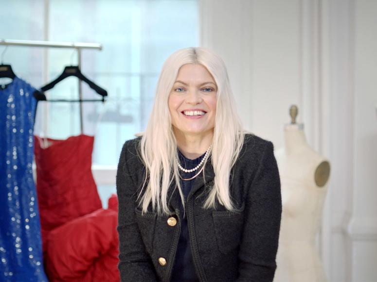 Stylist Kate Young in her office with high fashion dresses hanging in the background