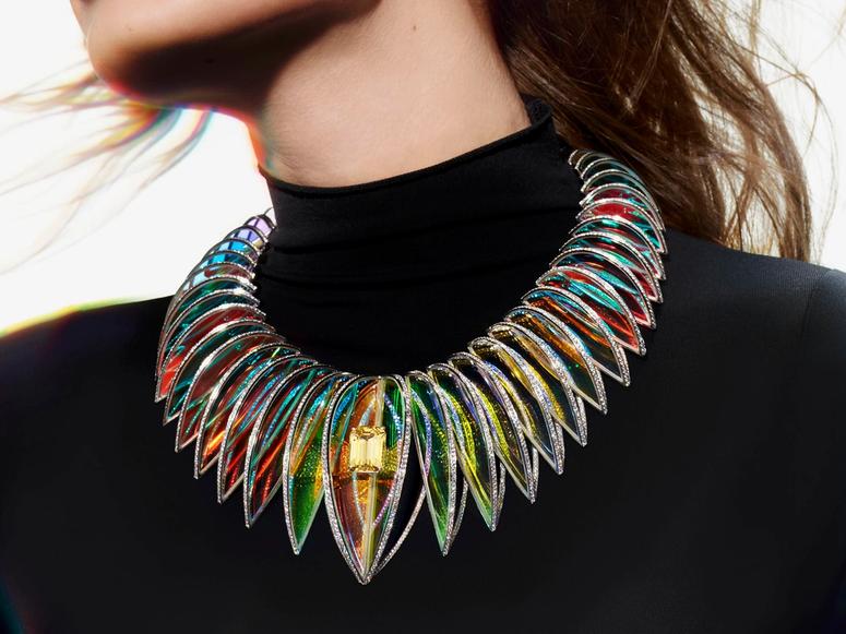 A holographic necklace with a yellow gem at the center