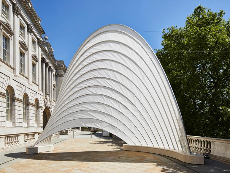 An arched white structure on a terrace 