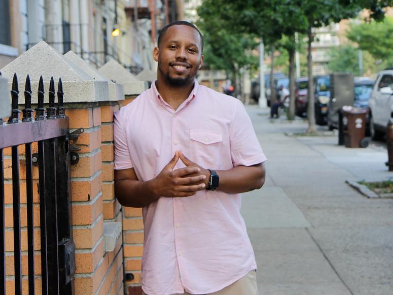 Eat Okra co-founder Anthony Edwards in a pink shirt on the sidewalk.