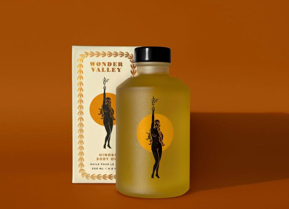 A bottle of Hinoki oil on an orange background.
