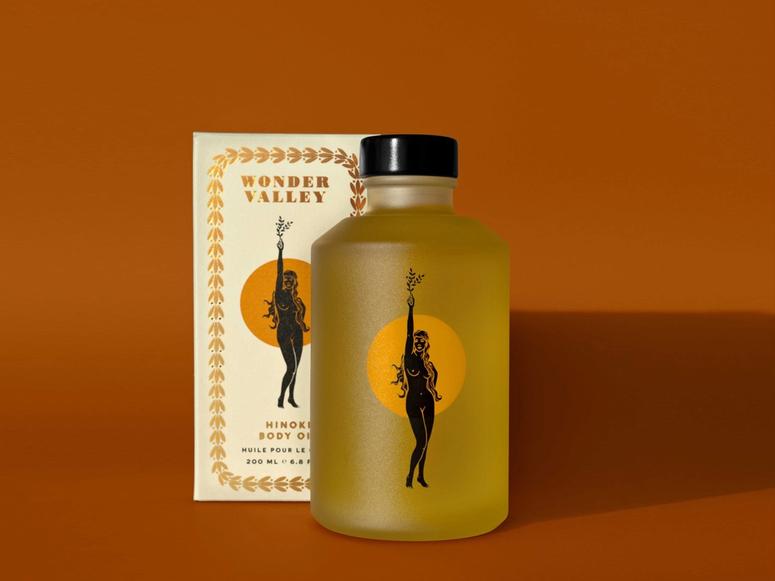 A bottle of Hinoki oil on an orange background.