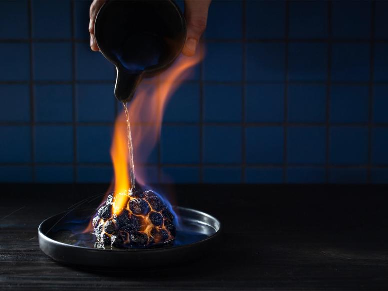 Barda dish being cooked by a flame