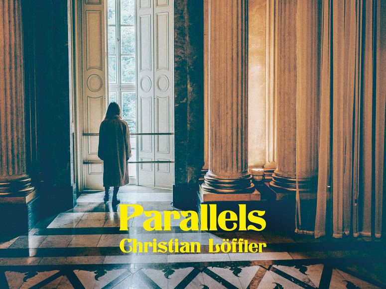 A man standing in a building looking out the window