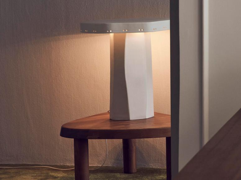 A white ceramic lamp on a wood table.