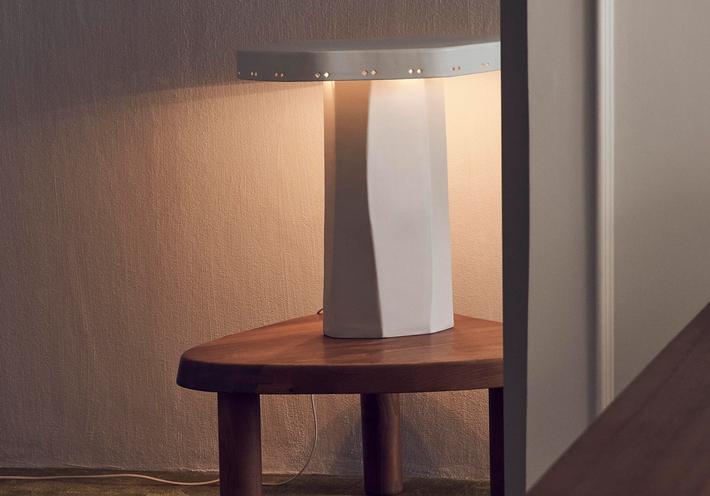 A white ceramic lamp on a wood table.