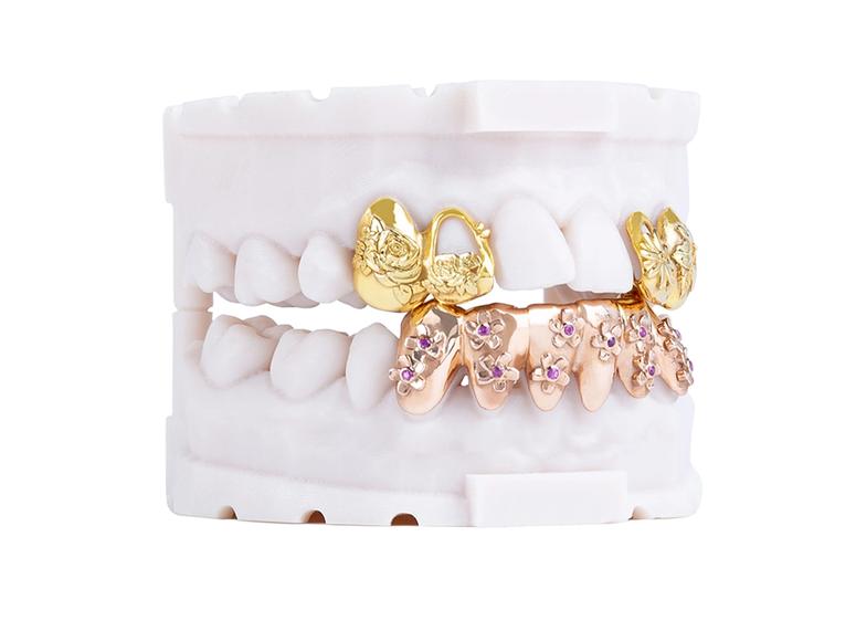 A pair of white denchers with gold and rose-gold grills.