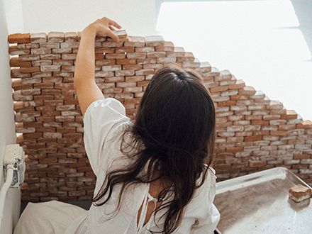 María Elena Pombo stacking bricks for an exhibition.