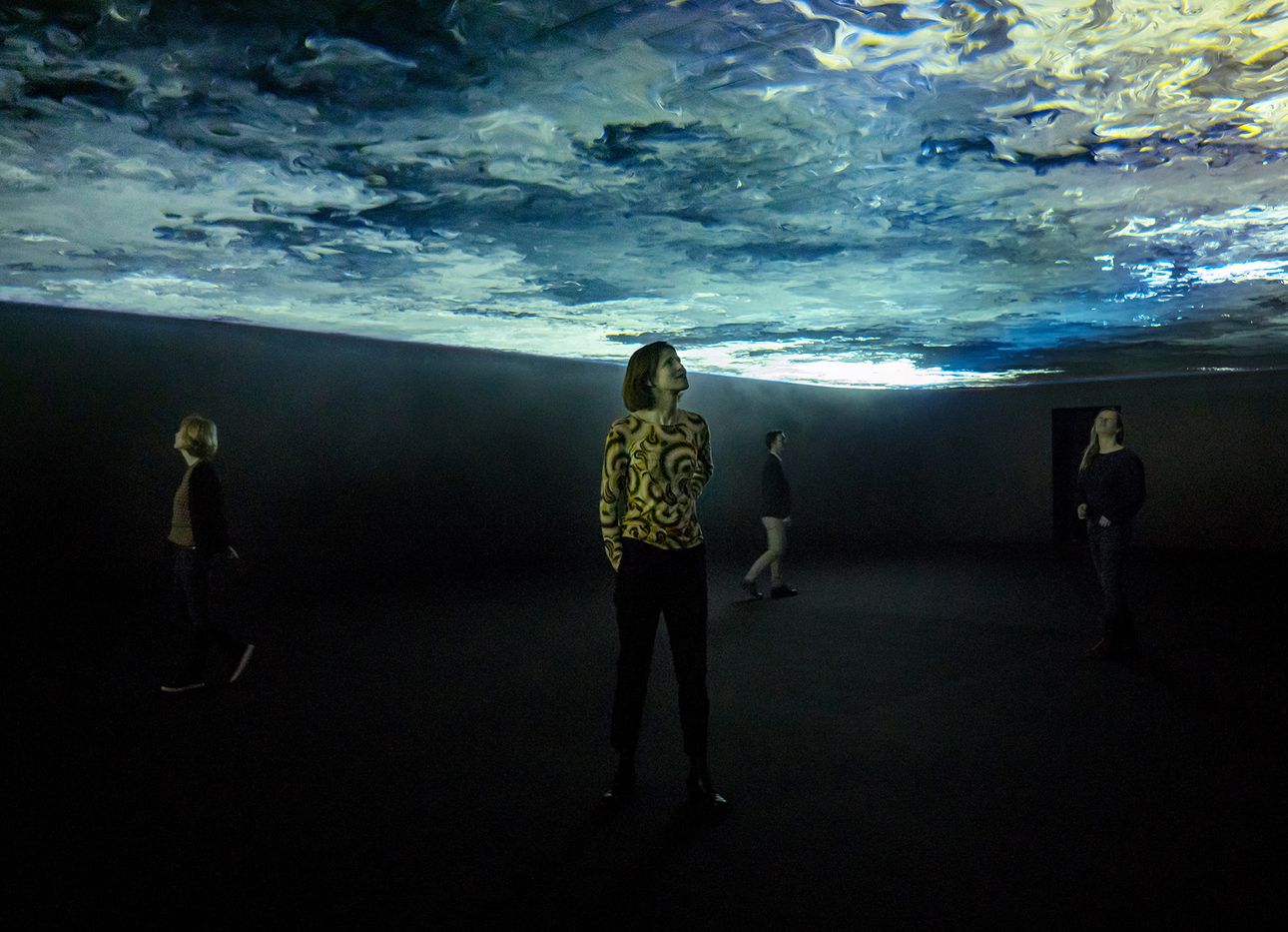 Three people underneath an Olafur Elaisson video installation.