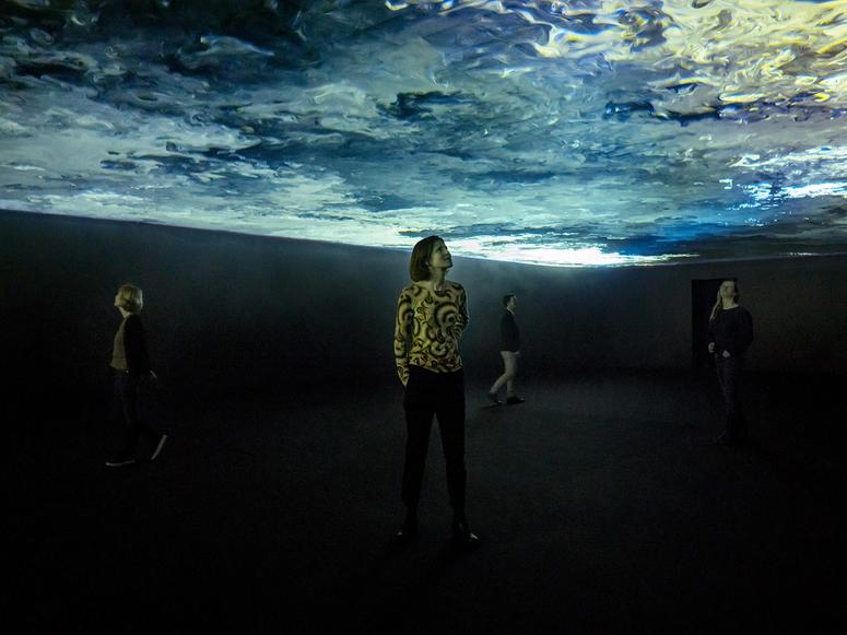 Three people underneath an Olafur Elaisson video installation.