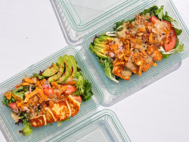 Two Case containers with multicolored salads inside.