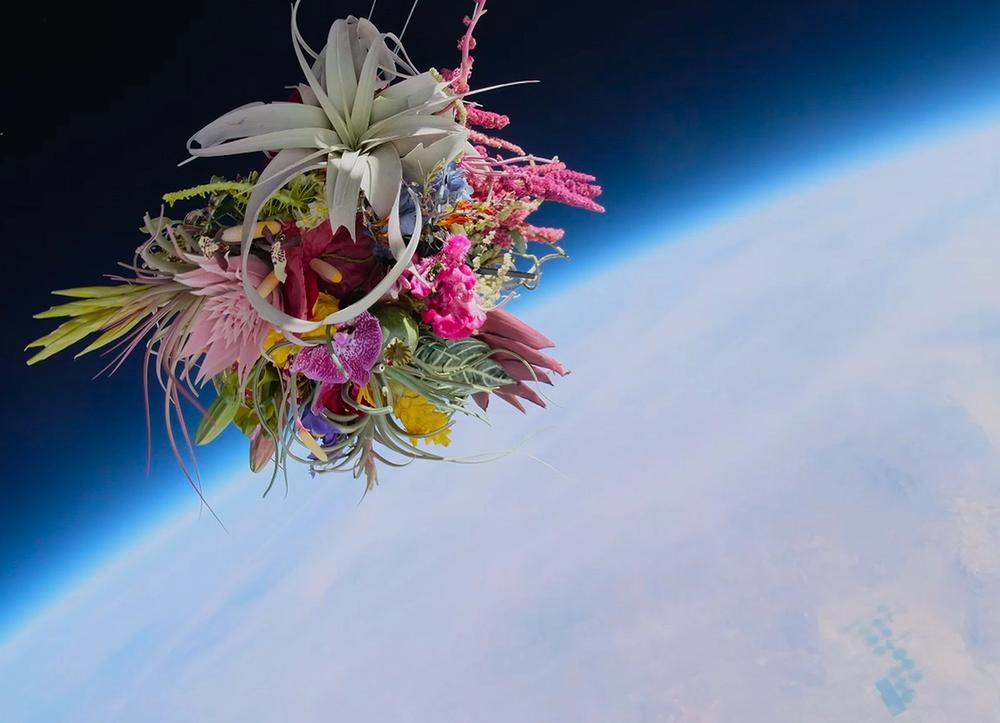 A bouquet of flowers floating in outer space above planet Earth