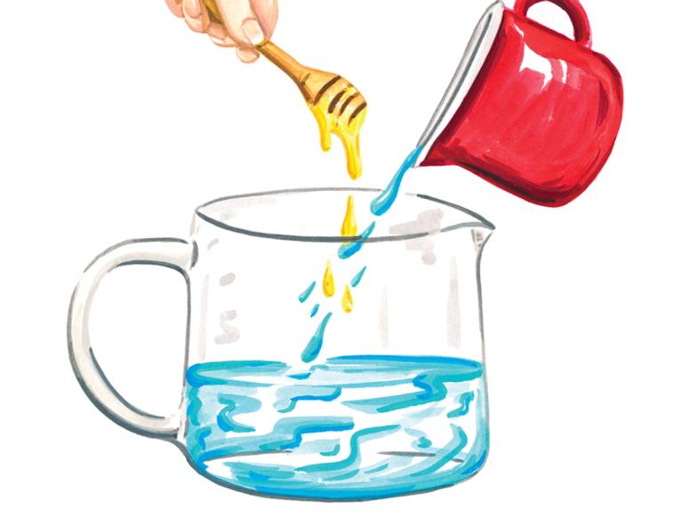 A pitcher of water with a hand holding a honey wand overhead.