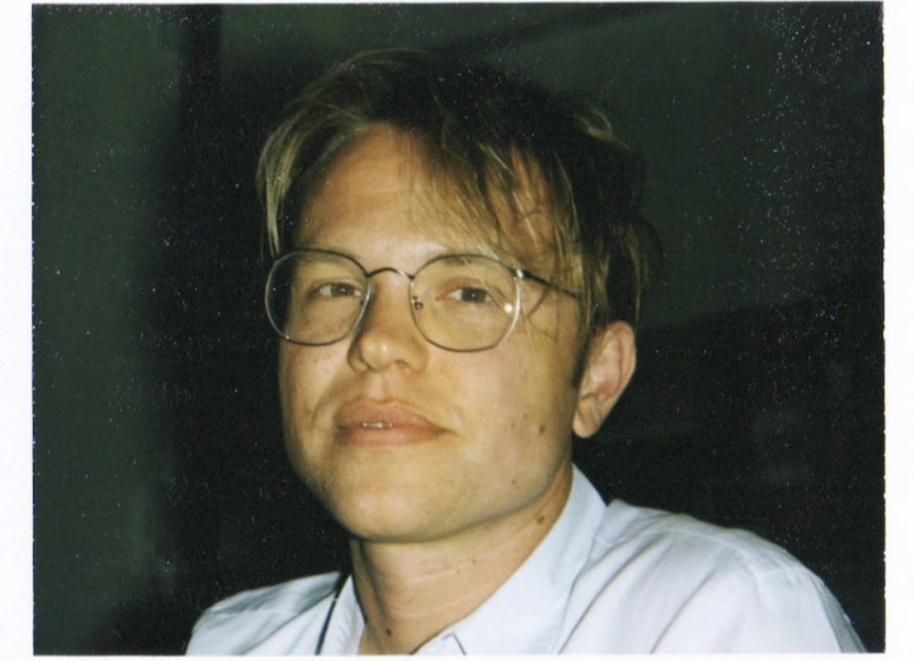 Caius Pawson in glasses with disheveled hair.