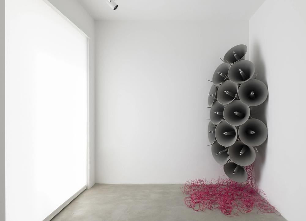 A series of bullhorns and purple wiring installed in a gallery corner.