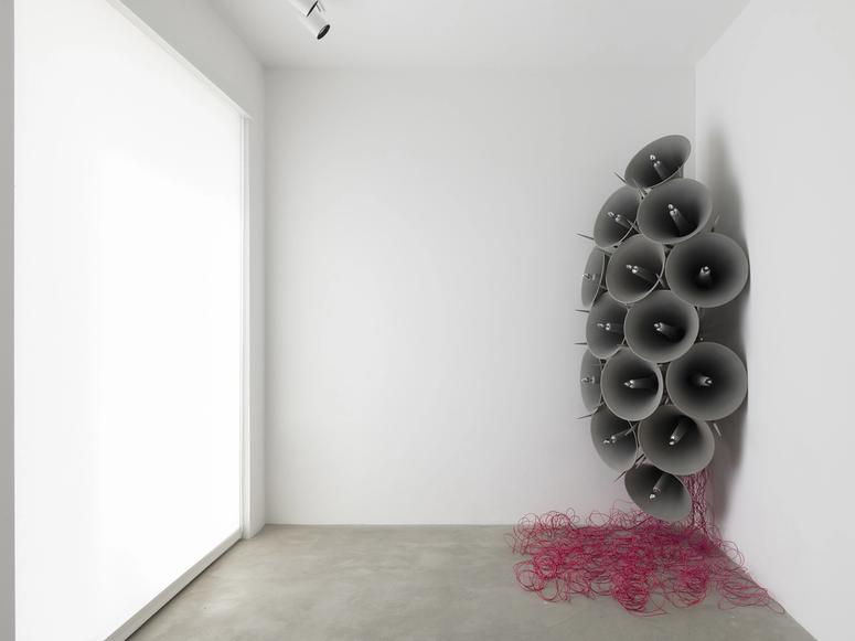 A series of bullhorns and purple wiring installed in a gallery corner.