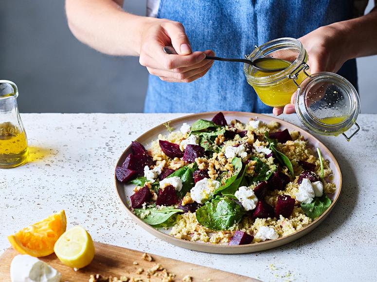 A woman making a beet and goat cheese salad.