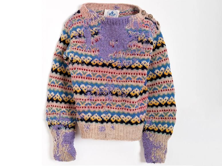 An old sweater darned with purple thread.