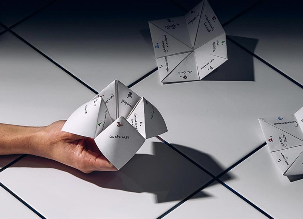 A hand holding a paper origami fortune teller
