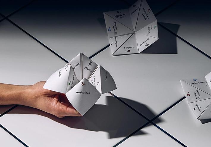 A hand holding a paper origami fortune teller