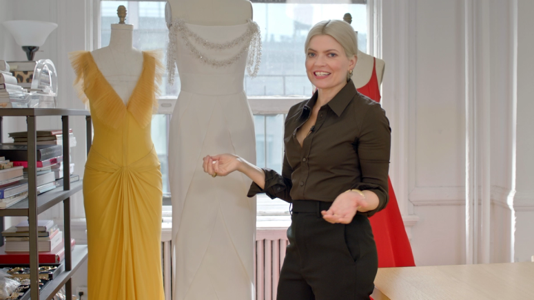 Stylist Kate Young with three red carpet dresses on mannequins 