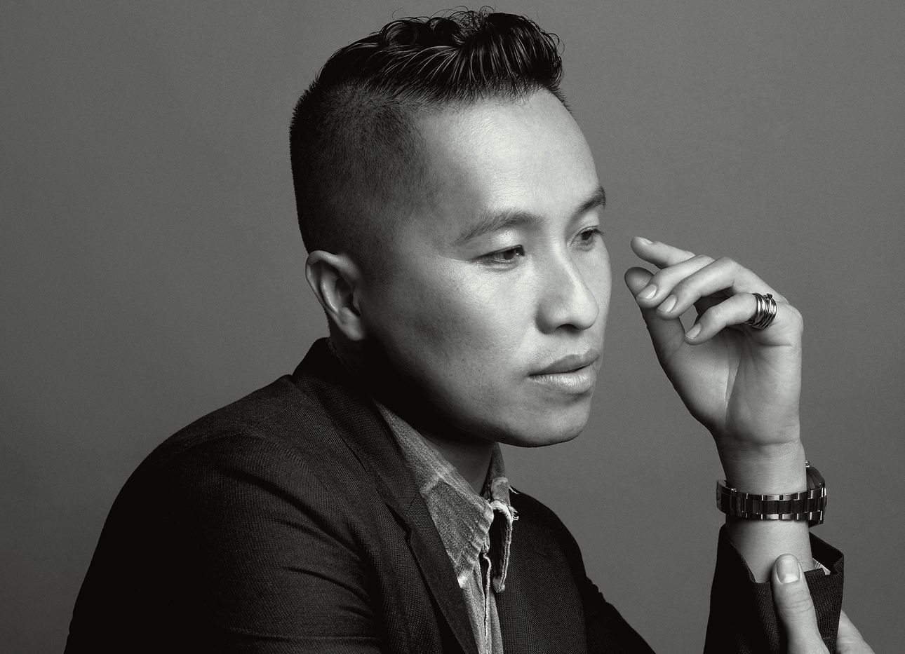 Fashion designer Phillip Lim in profile, in a suit, in a black and white photograph.