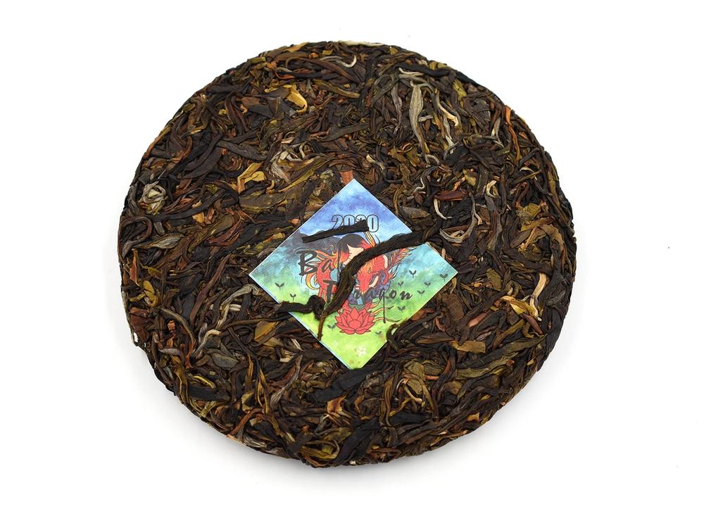 A cake of dried pu-erh with a colorful tag.