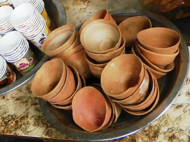 Several stacks of bhar on a tray next to paper cups.