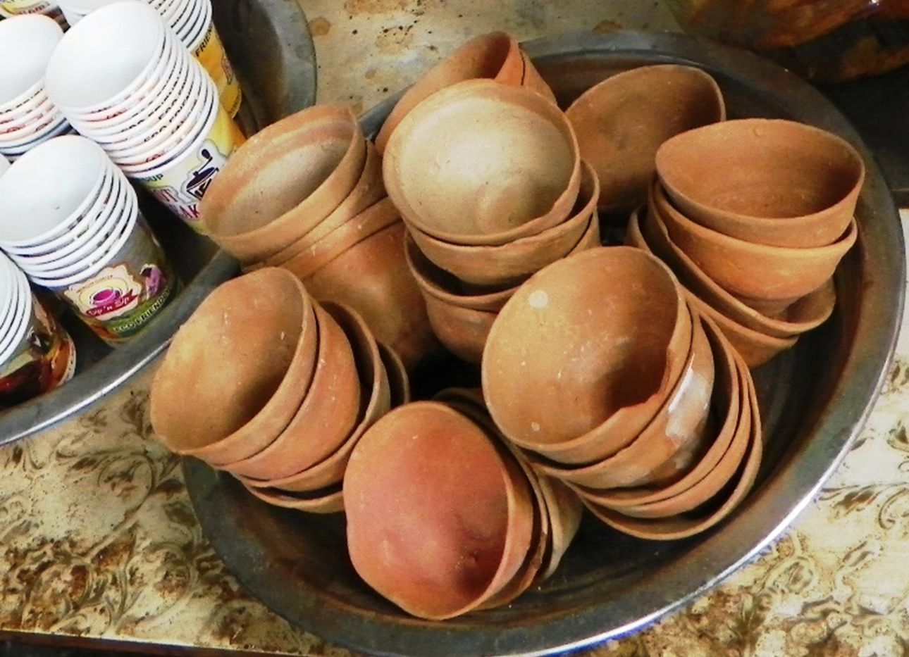 Several stacks of bhar on a tray next to paper cups.