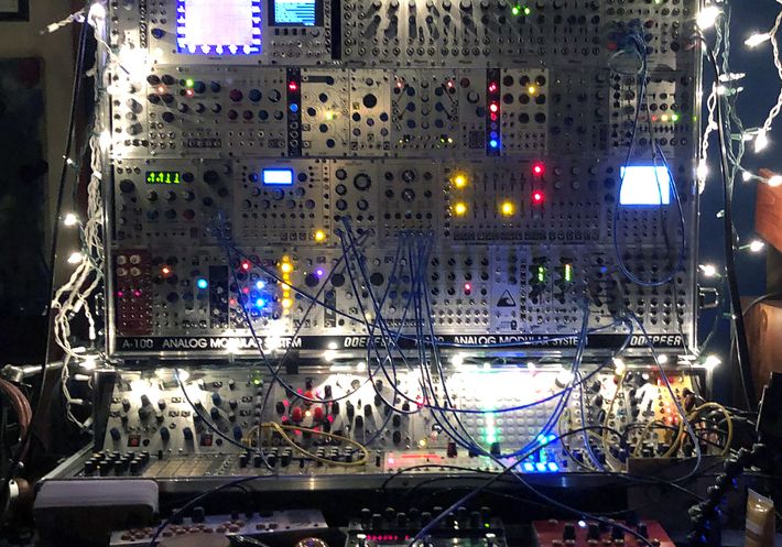 A large analog synthesizer covered in Christmas lights.