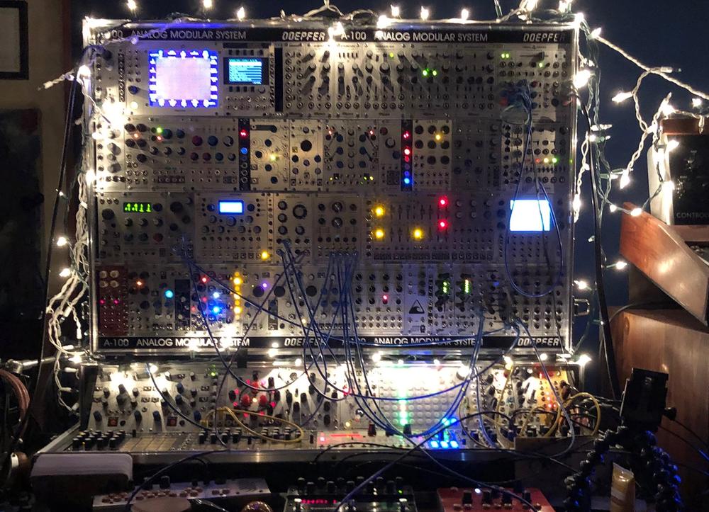 A large analog synthesizer covered in Christmas lights.