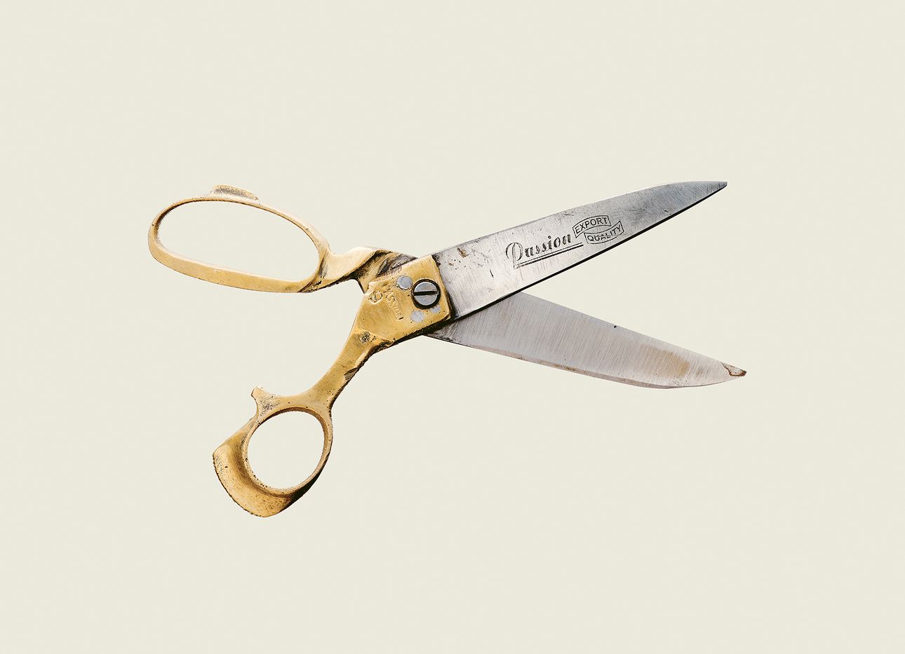 An old pair of scissors with a yellow handle.