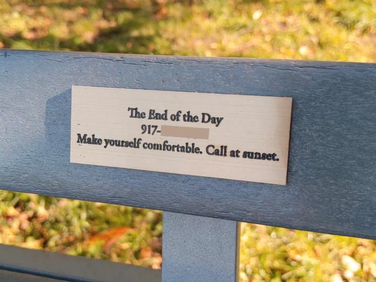 A bench with a gold plaque on it.