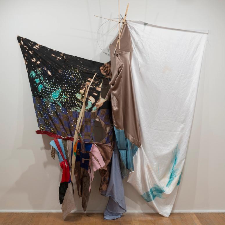 Artwork made from draped textiles and wood poles