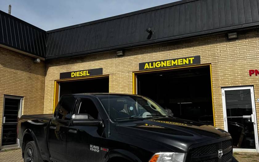 Ram 1500 EcoDiesel noir devant l’atelier