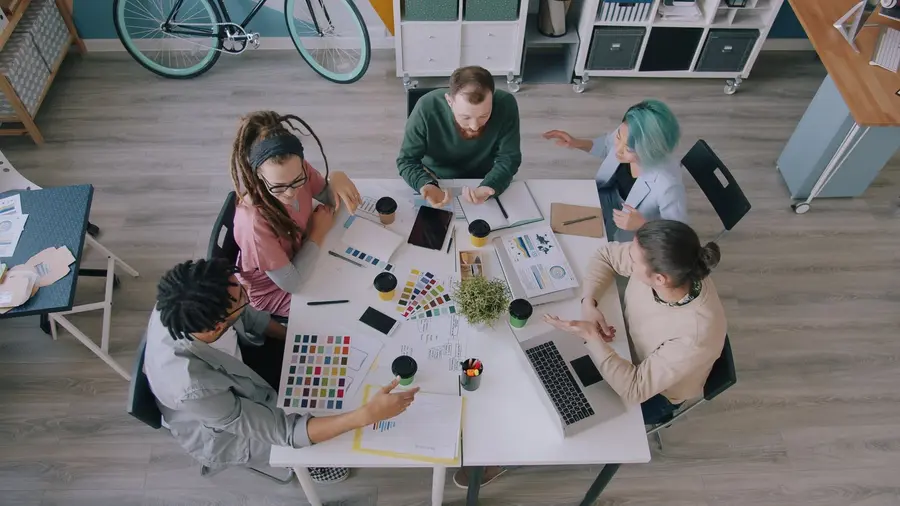Équipe pluridisciplinaire d'une agence de communication au travail autour d'une table