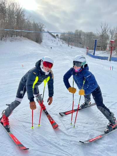 Two athletes side-slipping down a course together during inspection