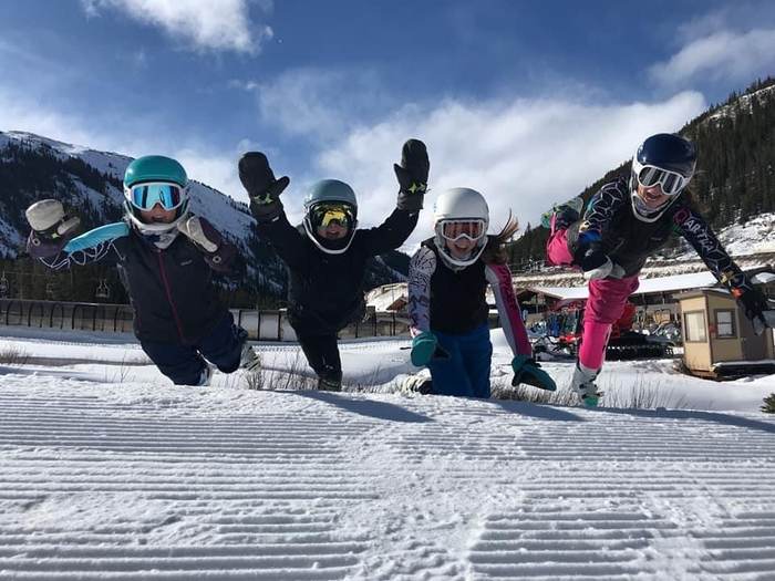 Four athletes jumping in the air together at the base area