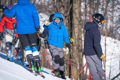 Coaches and athletes gathered at the top of a course in the trees
