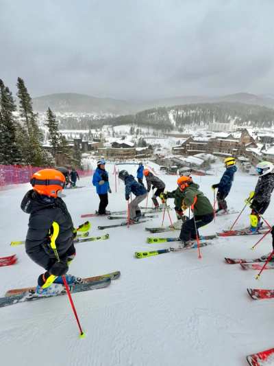 Young athletes and coaches at the top of a run with the hills behind