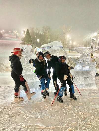 Athletes gathered with their skis under the lights during a night training session